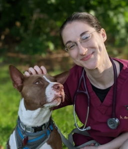 A veterinarian giving her dog head scratches