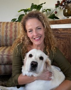 Curly haired woman hugging her senior Golden Retriever