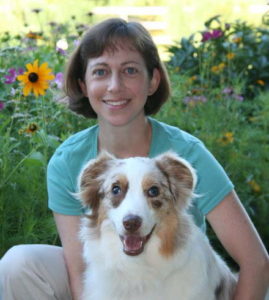A photo of Dr. Jessica Tartof and her heart dog Piper in a field of flowers.