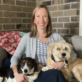 A woman holding her two dogs