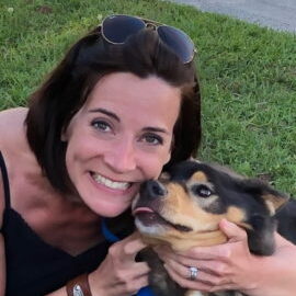 A female hugging her dog