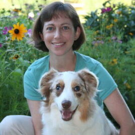 A photo of Dr. Jessica Tartof and her heart dog Piper in a field of flowers.